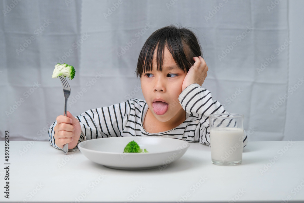 Children don't like to eat vegetables. Cute Asian girl refusing to eat ...