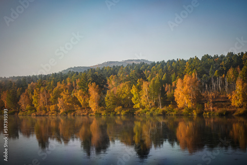 photo of the autumn forest, which stands on the river bank, autumn landscape, photo from the train window