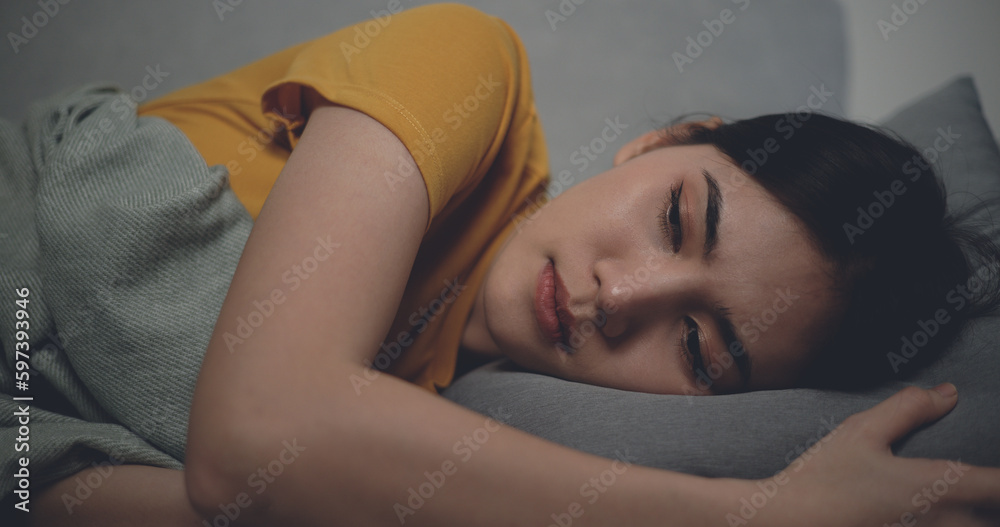 Sick woman covered with a blanket lying in bed with high fever Sick woman covered with a blanket lying in bed with high fever