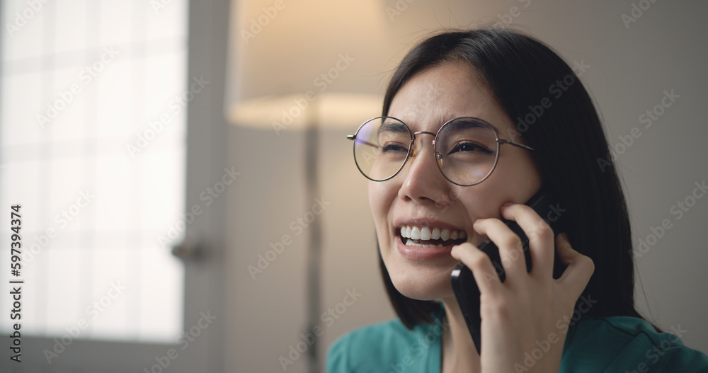 Cheerful Asian Young woman smile while chatting on smartphone in hand Cheerful Asian Young woman smile while chatting on smartphone in hand