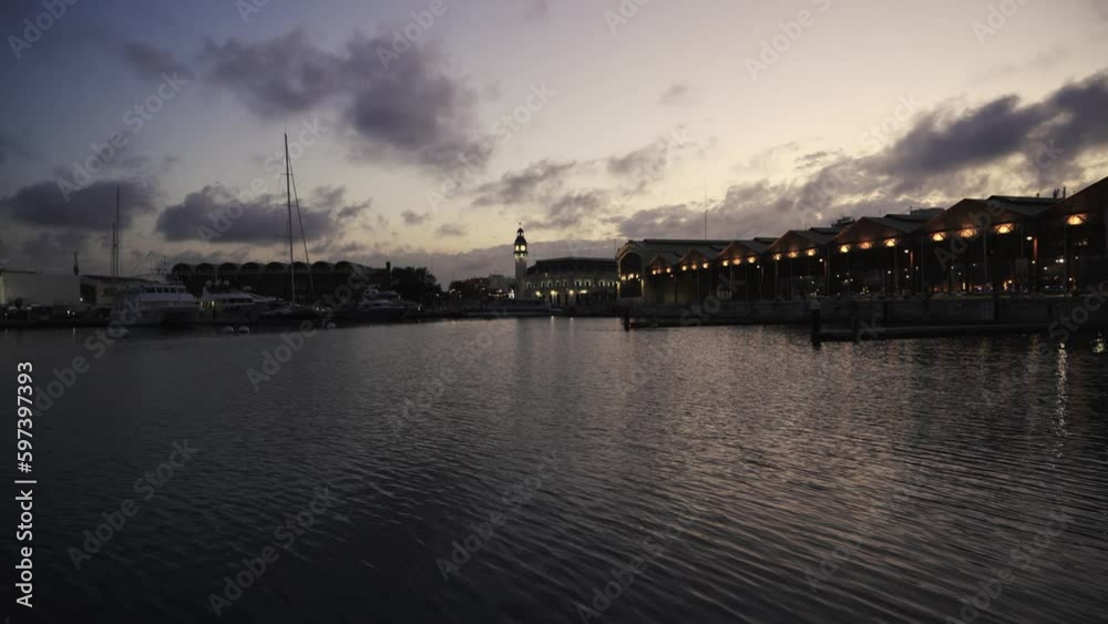 Late evening walk in the port of Valencia. The lights of the lanterns are reflected in the waves on a warm spring evening. Late evening walk in the port of Valencia. The lights of the lanterns are reflected in the waves on a warm spring evening.