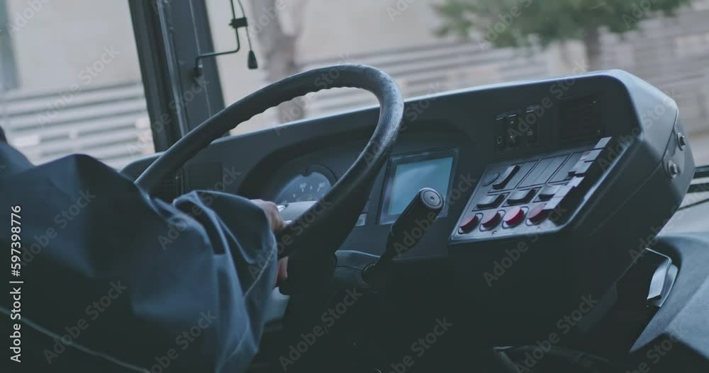 Close up of male hands. The driver is sitting at steering wheel of a bus