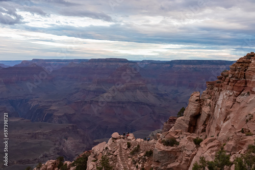 Panoramic aerial view from South Kaibab hiking trail at South Rim of Grand Canyon National Park, Arizona, USA, America. Colorado River weaving through valleys and rugged terrain. Clouds and overcast.
