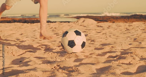 Child playing football on the beach, family fun outdoors players in soccer in dynamic action have fun playing football in summer day under sunlight.