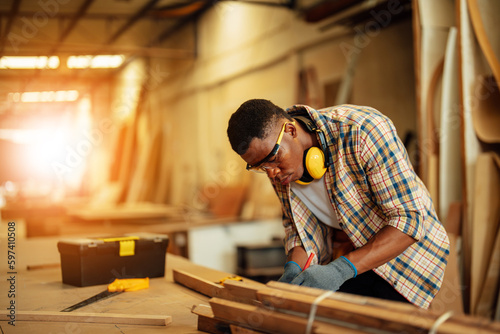 Carpenter man attend to making masterpiece woodworks handcrafted furniture fine measure in wood workshop.