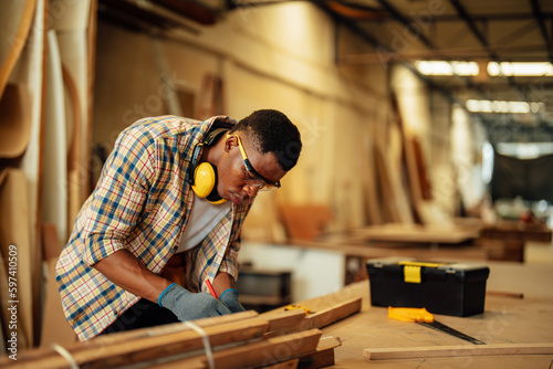 Carpenter man attend to making masterpiece woodworks handcrafted furniture fine measure in wood workshop.