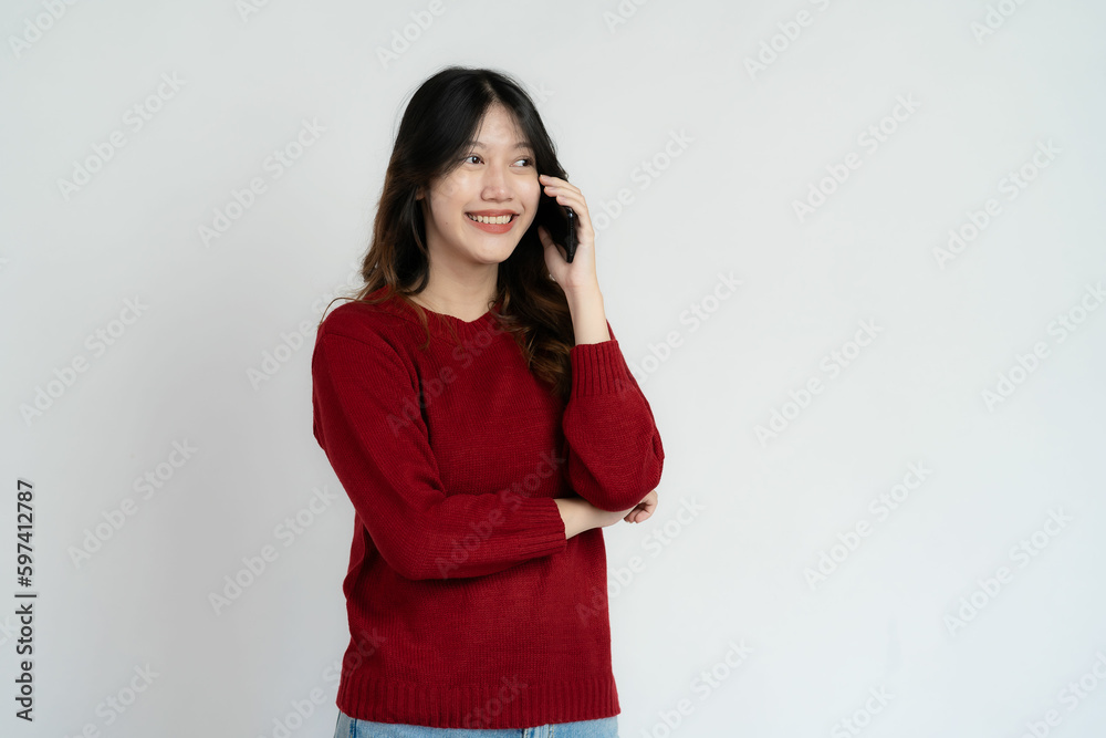 Young Asian woman holding smartphone pops up to chat with friend Black blank white screen on white background can be used for advertising or product presentation. Young Asian woman holding smartphone pops up to chat with friend Black blank white screen on white background can be used for advertising or product presentation.