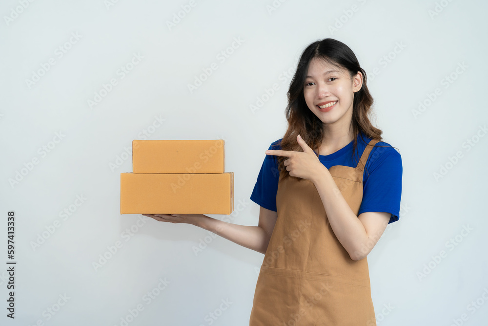 Beautiful excited young asian woman with yellow cardboard box standing on isolated white background. Cheerful woman holding parcel box received from courier service, online shopping concept Beautiful excited young asian woman with yellow cardboard box standing on isolated white background. Cheerful woman holding parcel box received from courier service, online shopping concept