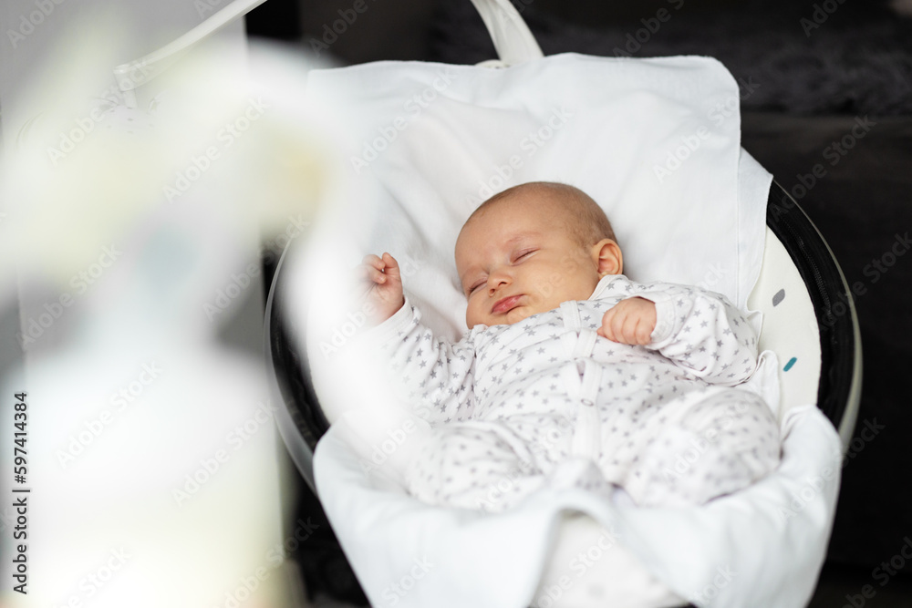Adorable baby sleeps in baby rocker in room. Newborn concept. Adorable baby sleeps in baby rocker in room. Newborn concept.