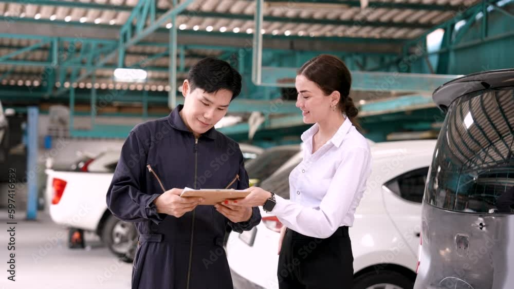 Garage staff discussing the damage and expenses incurred from repairing the car. Charge the difference after deducting from insurance already. Caucasian woman pays for car repairs by credit card