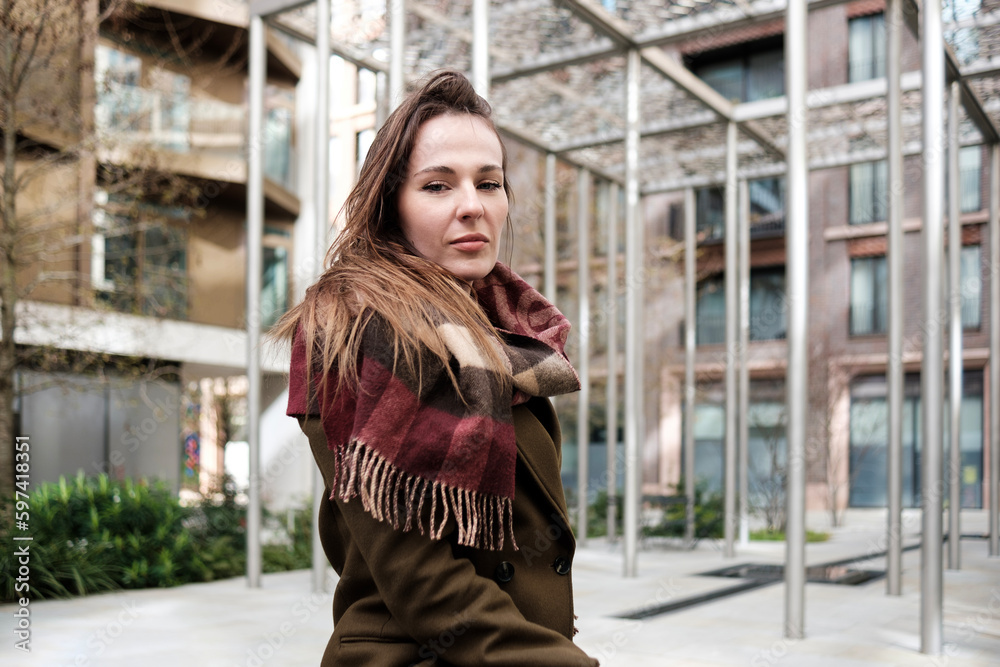 Fototapeta premium Woman looking at camera with metal structure behind.