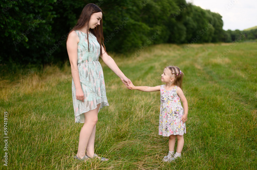 Portraits of joyful mother and daughter spend time together, enjoy happy family time, walk in the park. The concept of a happy family, family day,mother's day, countryside vacation, unity with nature. Portraits of joyful mother and daughter spend time together, enjoy happy family time, walk in the park. The concept of a happy family, family day,mother's day, countryside vacation, unity with nature.