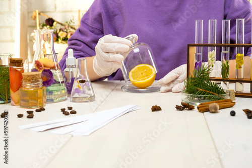 Preparation of perfumes from natural ingredients, aromatherapy. Fresh flowers and natural ingredients in chemical test tubes and flasks