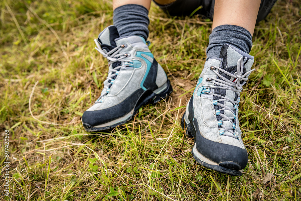 Legs in hiking boots on green grass Legs in hiking boots on green grass