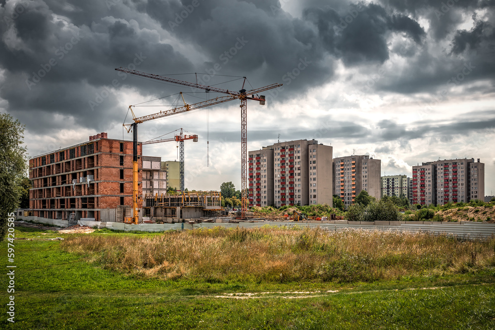 Industrial crane on construction site under cloudy sky