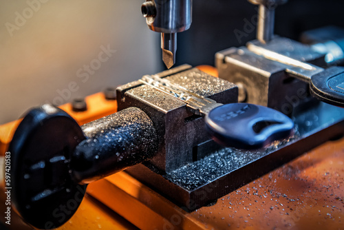 Locksmith in workshop makes new key duplicate