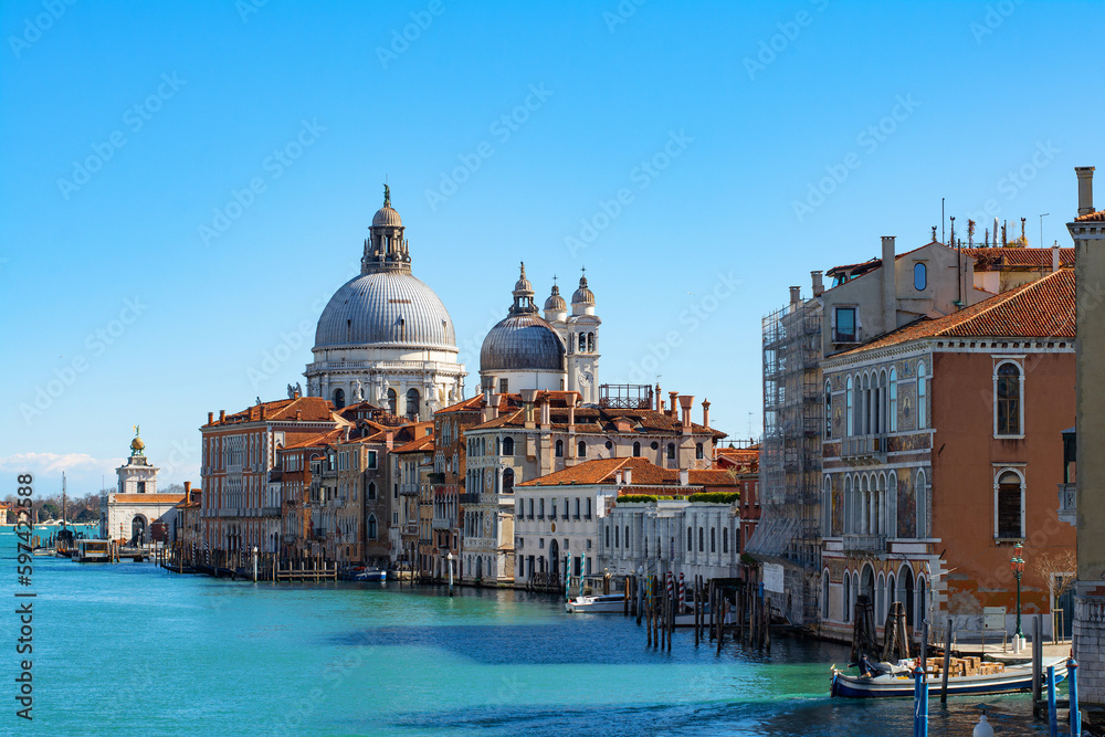 Stunning view of the Venice skyline with the Grand Canal and Basilica Santa Maria Della Salute in the distance  from Ponte Dell’ Accademia in a sunny weather with clear sky. Veneto, Italy