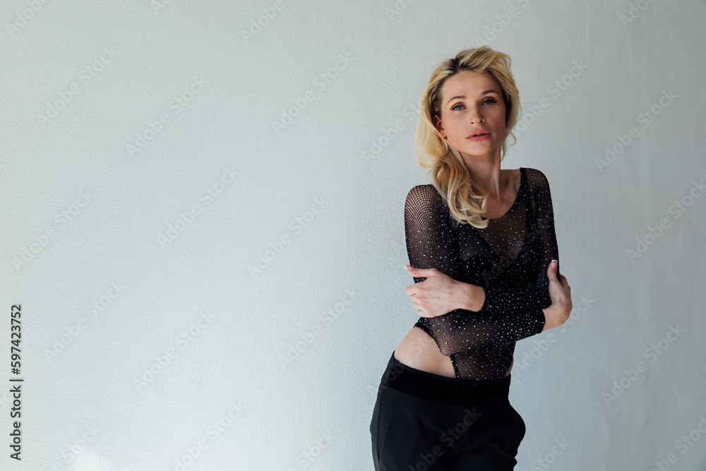 Fototapeta premium beautiful blonde in black fashionable clothes on a white background