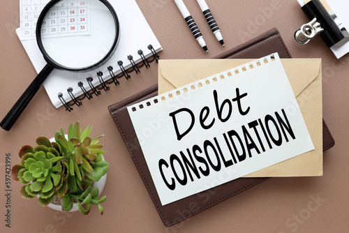 Foto debt consolidation, Office desk with text on a notebook