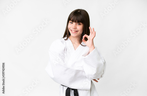 Little caucasian girl over isolated white background showing ok sign with fingers
