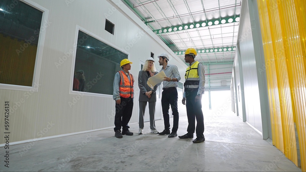 Group of factory warehouse workers standing and talking in warehouse for work wearing safety hardhats helmet inspection at warehouse