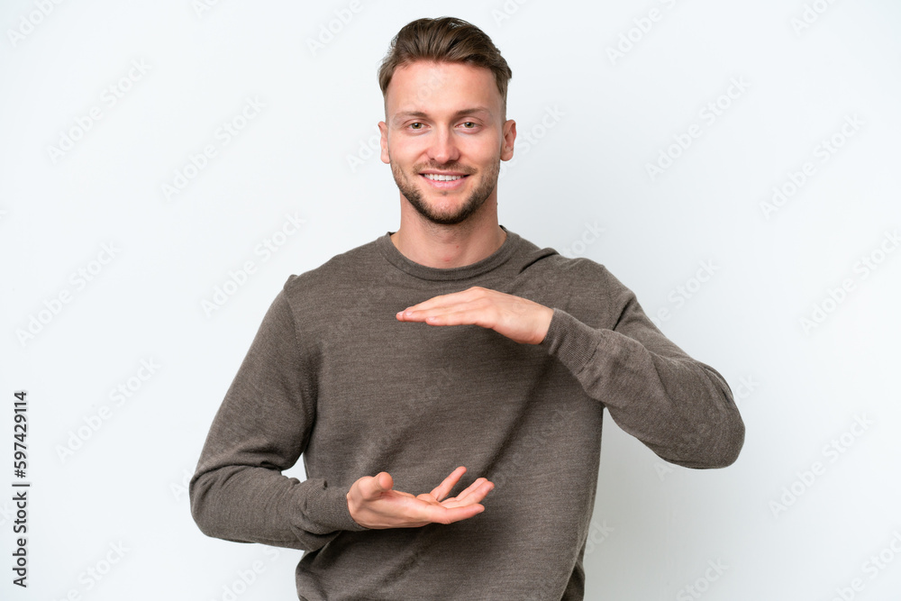 Young blonde caucasian man isolated on white background holding copyspace imaginary on the palm to insert an ad Young blonde caucasian man isolated on white background holding copyspace imaginary on the palm to insert an ad