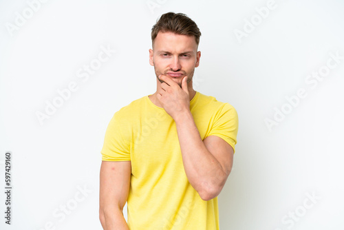 Young blonde caucasian man isolated on white background having doubts