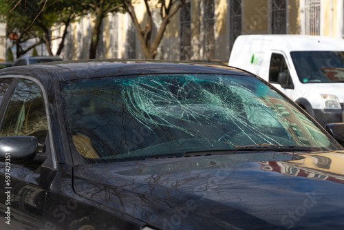 Broken windshield of the car. Car after an accident with a broken glass. Broken windshield after a hurricane