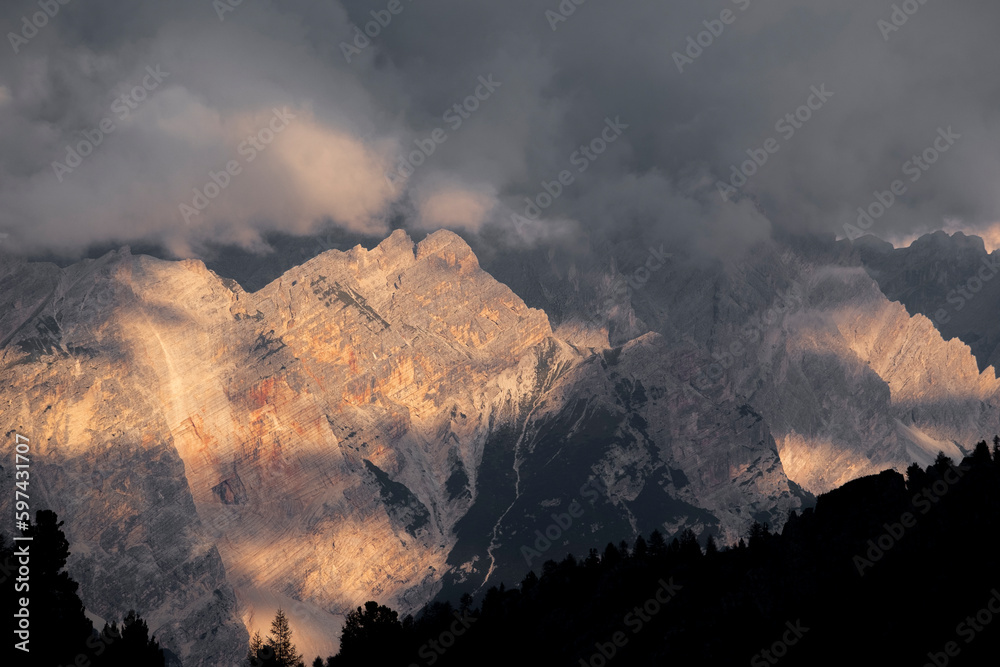 Sunset light on the dolomite  peaks mountain hidden by low clouds
