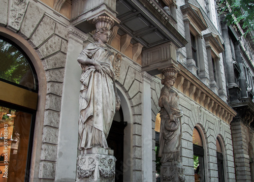 Exterior view of a historical building in the old town Budapest, Hungary, Europe. Ancient statues, figures, and ornaments decorate an old house on Andrassy Avenue, the most famous boulevard in town. photo