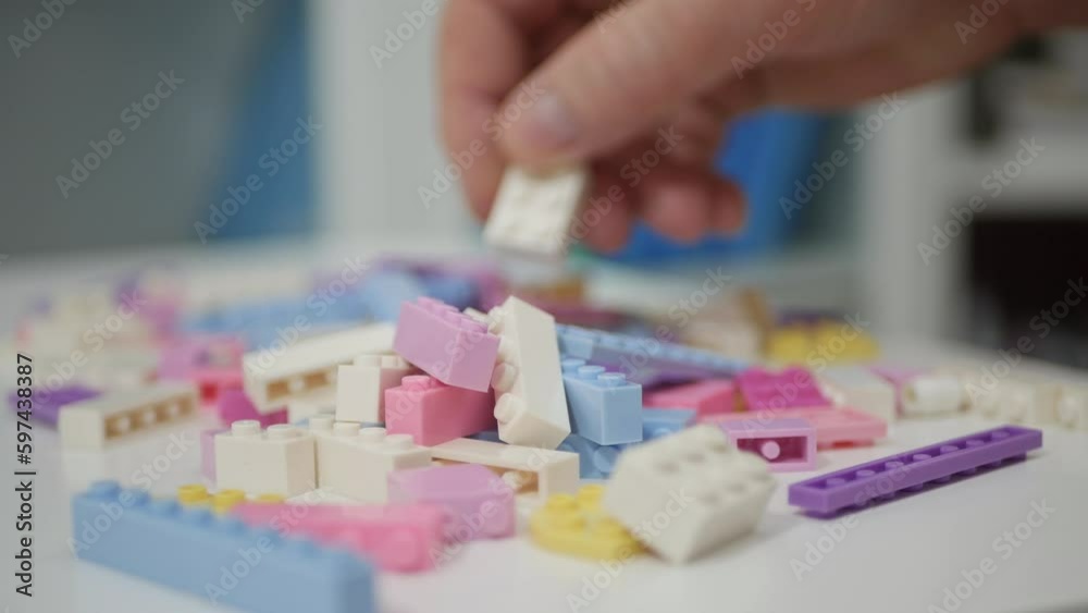 Blurred Shooting with an Elderly Person Playing Like a Child with Colorful Small Toy Bricks on the Table. Blurred Shooting with an Elderly Person Playing Like a Child with Colorful Small Toy Bricks on the Table.