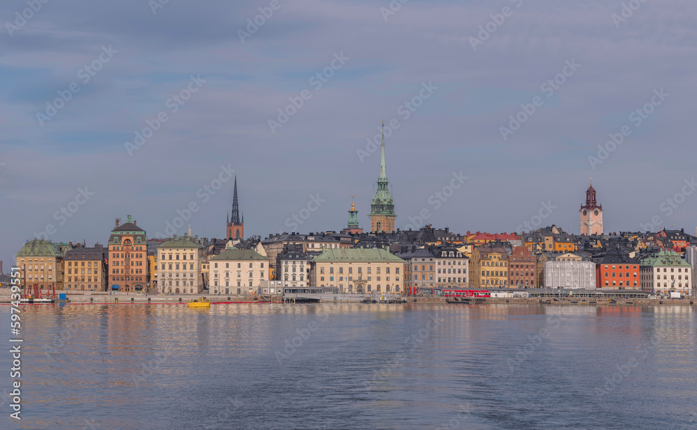The old town Gamla Stan with 1700s houses and churches at the water front, a tranquil early sunny spring day in Stockholm