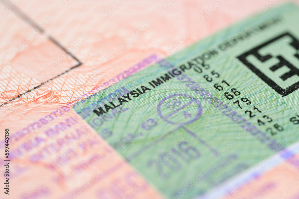 close-up part of page of document, foreign passport for travel with Malaysia visa, tourist visa stamp with hologram with shallow depth of field, passport control at border, travel in Southeast Asia close-up part of page of document, foreign passport for travel with Malaysia visa, tourist visa stamp with hologram with shallow depth of field, passport control at border, travel in Southeast Asia