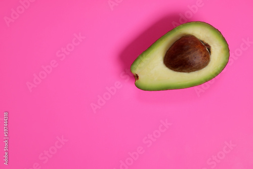 Raw ripe avocado on pink background, weight loss concept. copy space for text