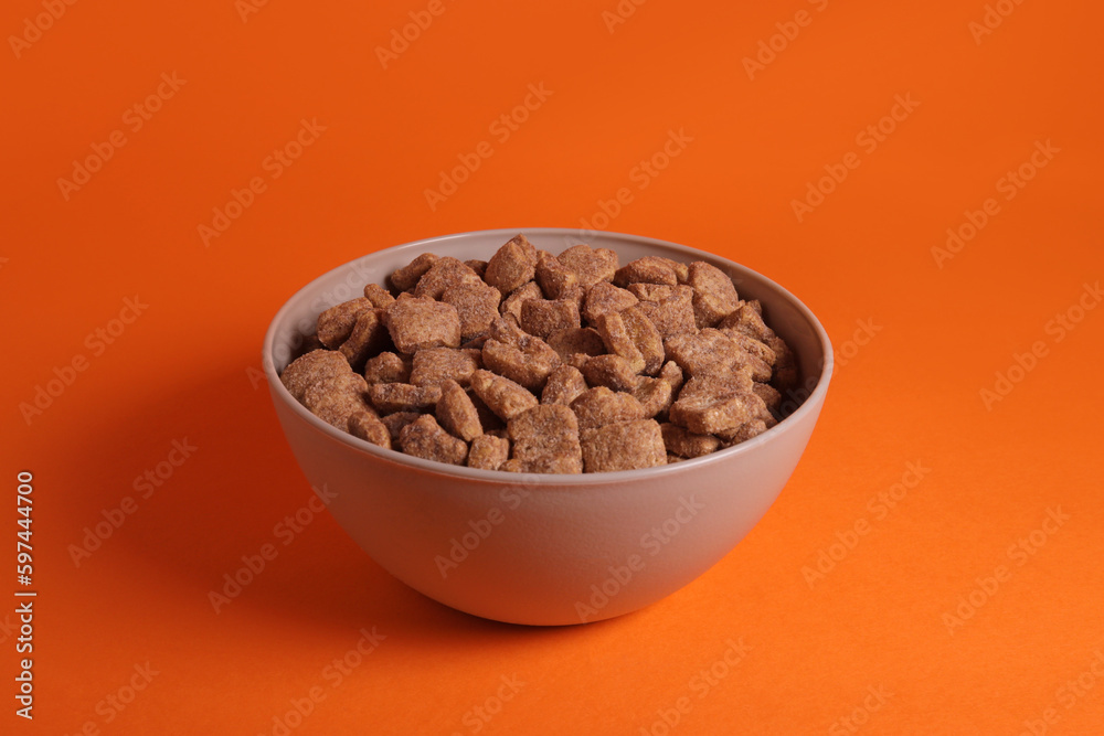 Chocolate corn snacks pads, dry breakfast in a bowl on an orange background Chocolate corn snacks pads, dry breakfast in a bowl on an orange background