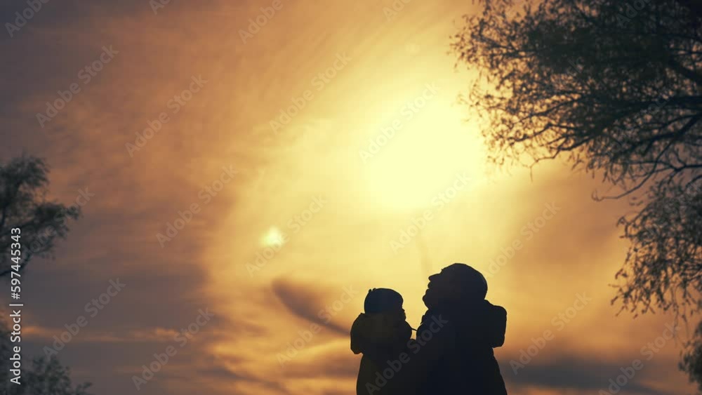 father throws up baby silhouette in the park. happy family kid dream