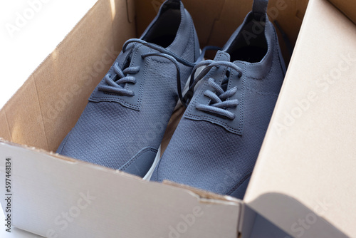 Sneakers in brown cardboard shoes box