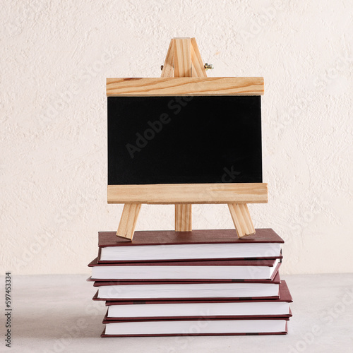 black board for text on stack of books on white background. copy space. Education and exhibitions, meetings concept. Back to school. square