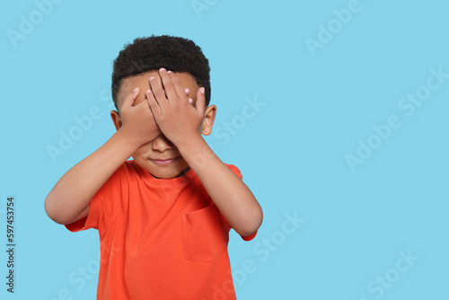 Emotional African-American boy on turquoise background. Space for text