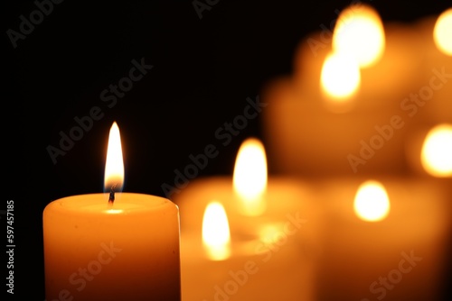 Burning candle on black background, closeup. Space for text © New Africa