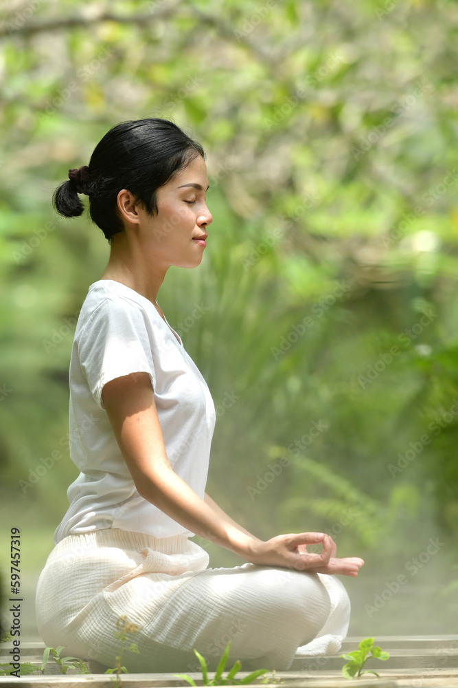 Asian woman meditating in the woods. Forest yoga. Mindfulness. Asian woman meditating in the woods. Forest yoga. Mindfulness.