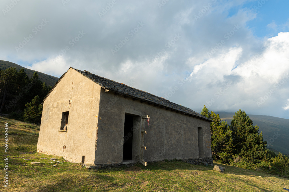 Obraz premium Summer landscape with mountain hut and cloudy sky