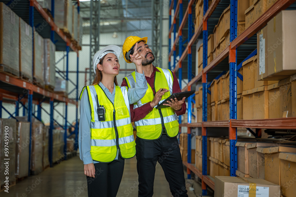 Warehouse employees reading a clipboard in a logistics centre,Warehouse worker taking packages for shipment in a large distribution centre. Warehouse employees reading a clipboard in a logistics centre,Warehouse worker taking packages for shipment in a large distribution centre.