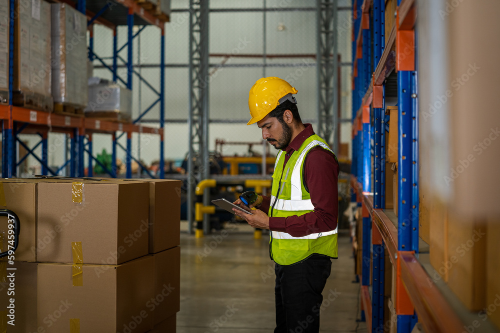 Warehouse employees using digital tablet computer for checking stock in a large distribution warehouse. Warehouse employees using digital tablet computer for checking stock in a large distribution warehouse.