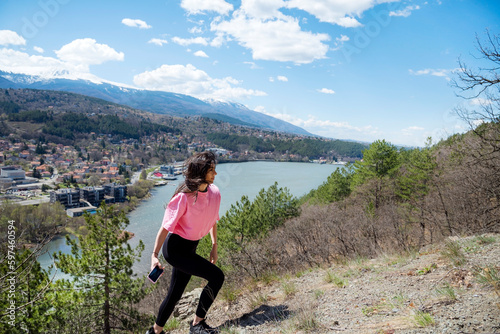 Woman hiking in the mountain high above a blue lake with stunning panoramic view .Traveling in the nature in Bulgaria 