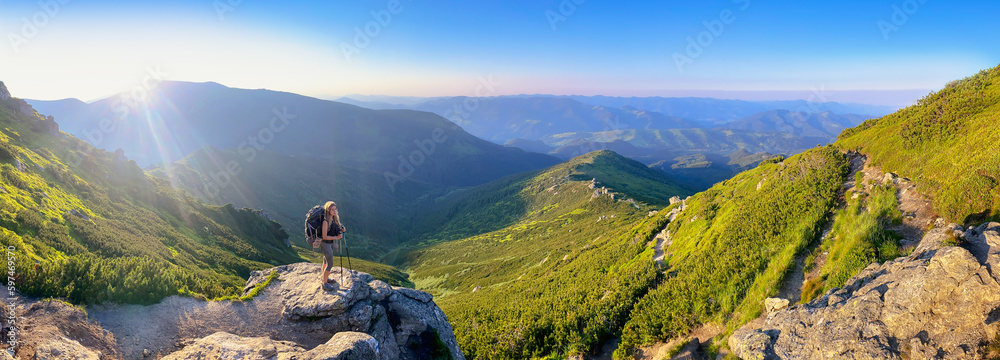 Young woman and her dog on mount Vuhaty Kamin. Panorama. Chornohora ridge, Carpathian mountains, Ukraine. - obrazy, fototapety, plakaty 