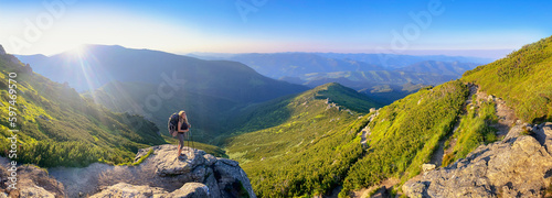 Young woman and her dog on mount Vuhaty Kamin. Panorama. Chornohora ridge, Carpathian mountains, Ukraine.
