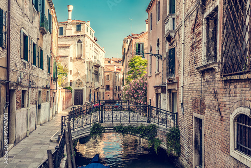 Romantic canal in Venice, Italy with scenic bridge.