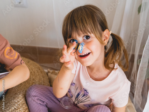 niña con una mariposa jugando 
