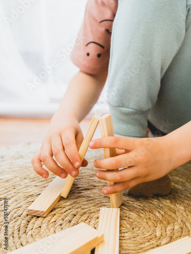 Manos niño jugando con maderas